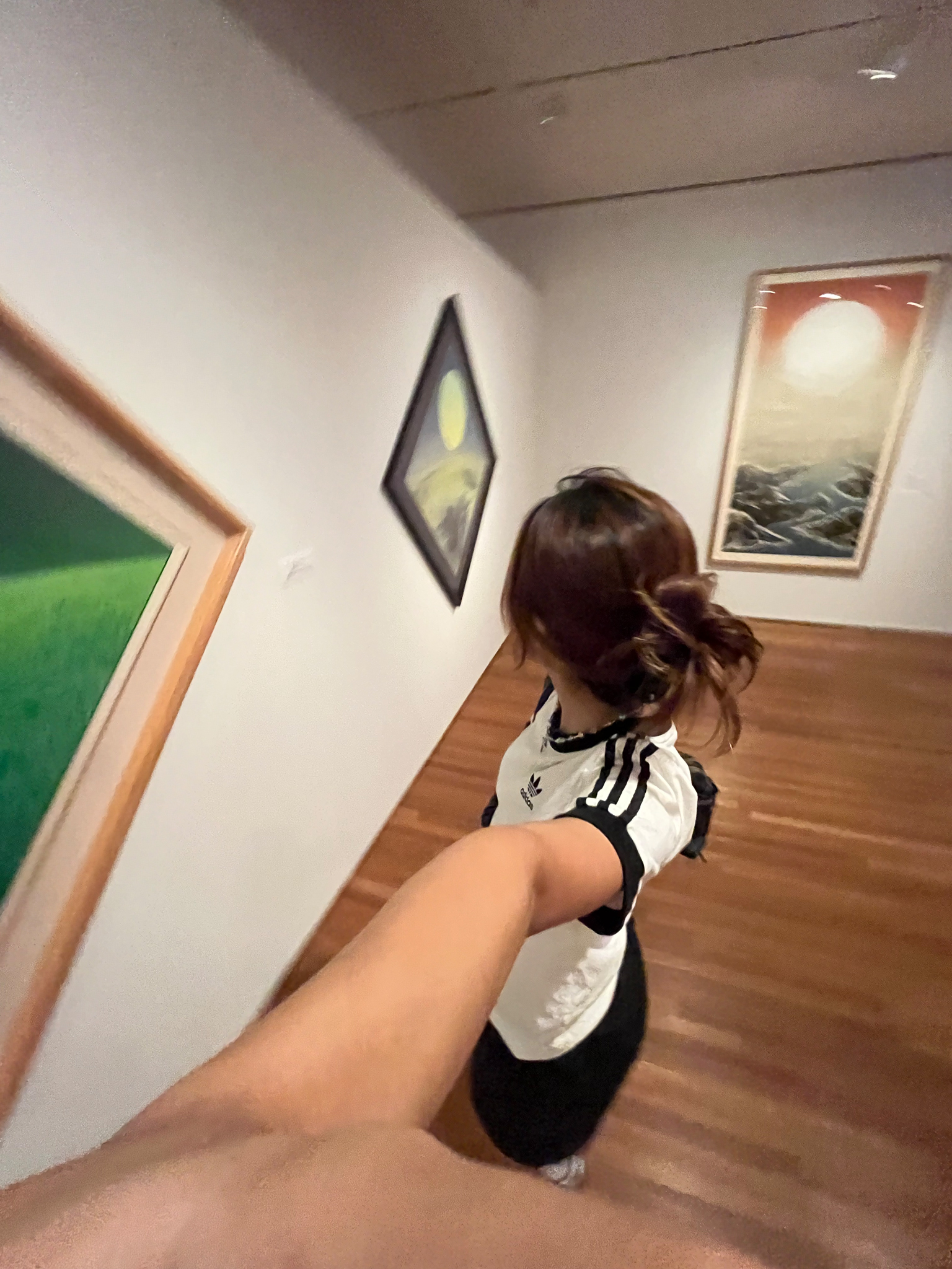 A selfie of a woman looking at an artwork in an exhibition