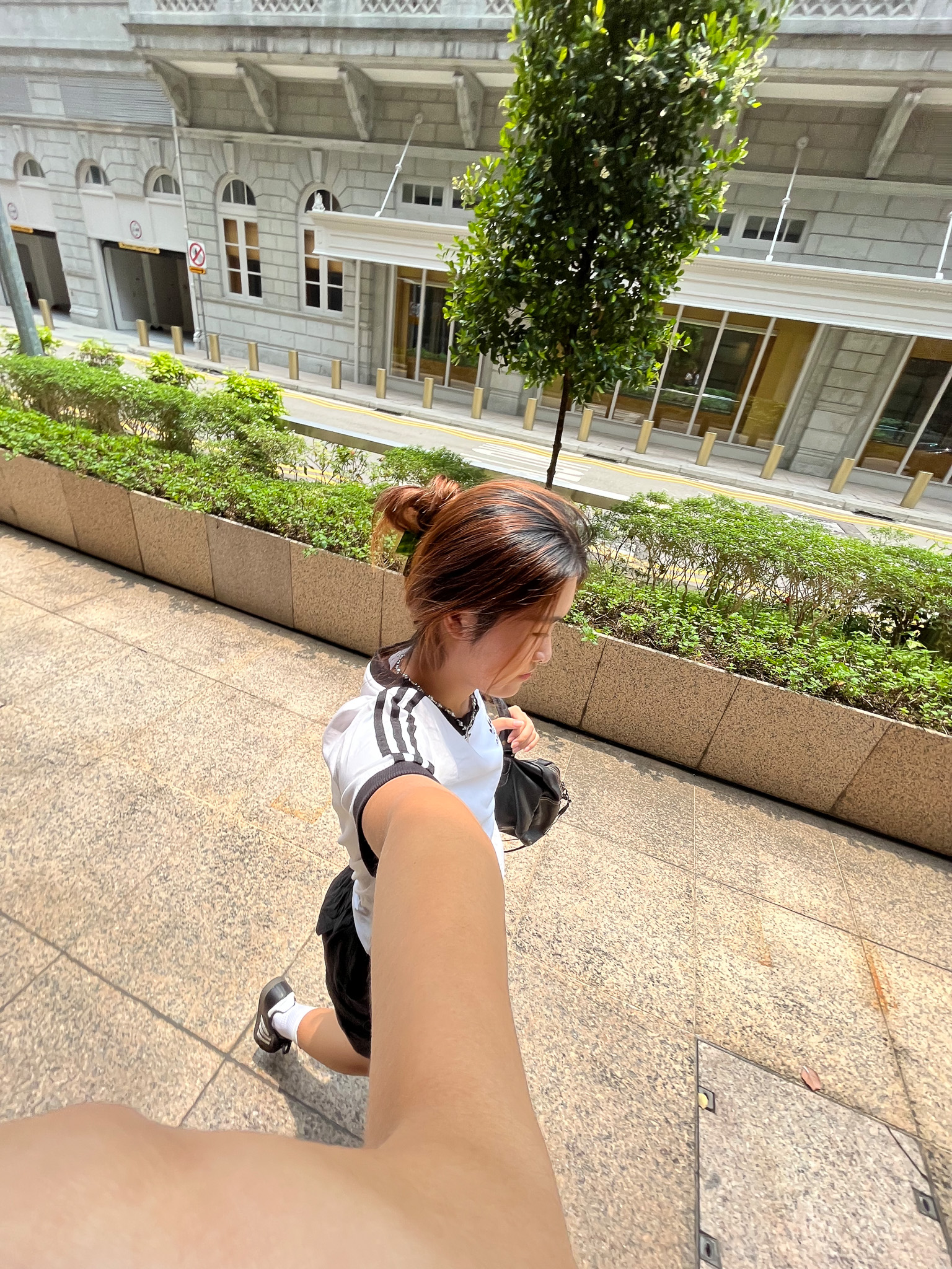 A wide angle selfie of a woman walking, looking straight ahead.